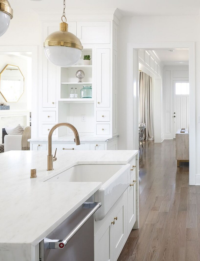 Brass Kitchen Faucet and farmhouse sink. I love how much warmth brass can bring to a white kitchen! White kitchen with brass lighting, brass faucet and brass hardware. #brass #kitchen #faucet #hardware #lighting #farmhousesink Ramage Company. Leslie Cotter Interiors, LLC