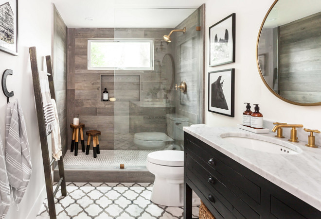 Farmhouse Bathroom. Farmhouse bathroom featuring off-white walls, marble flooring, wood-like shower tile and rustic black vanity. #Farmhousebathroom #farmhouse #bathroom #tile #woodliketile #rusticvanity #offwhite Juxtaposed Interiors