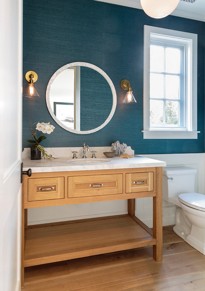 Bathroom stained blue seagrass wallpaper, open vanity with marble top, round mirror, glass cone sconces and wall paneling. Bathroom stained seagrass wallpaper, open vanity with marble top, round mirror, glass cone sconces and wall paneling #Bathroom #stainedseagrasswallpaper #seagrasswallpaper #openvanity #marbletop#roundmirror #glassconesconce #glassconesconces #bluewallpaper #wallpaneling Haefele Design