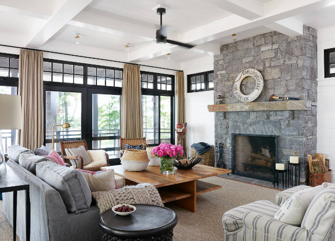 Modern Farmhouse Living room with grey stone fireplace and black windows and black doors with transoms. Modern farmhouse living room black windows black doors grey stone fireplace. Modern Farmhouse Living room with grey stone fireplace and black windows and black doors with transoms. Modern farmhouse living room black windows black doors grey stone fireplace #ModernFarmhouse #ModernFarmhouseLivingroom #FarmhouseLivingroom #greystonefireplace #stonefireplace #blackwindows #blackdoors #transoms #Modernfarmhouselivingrooms Jennifer Worts Design Inc