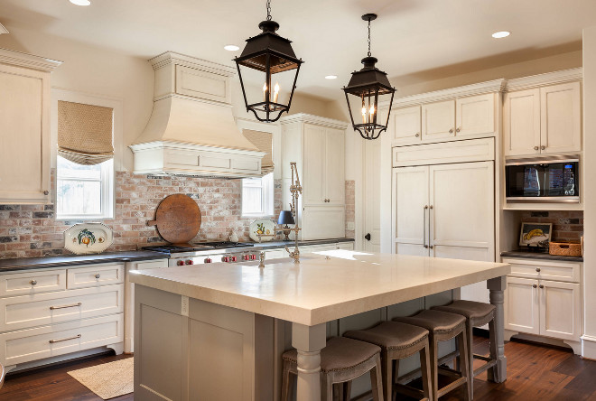 Traditional Cream White Kitchen with light glazed cabinets, warm grey island and exposed brick backsplash #traditionalkitchen #creamwhitekitchen #creamwhitekitchencabinets #glazedcabinet #lightlyglazedcabinets #exposedbrick #exposedbrickbacksplash #brickbacksplash Frankel Building Group