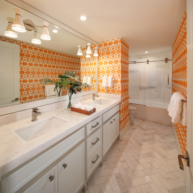 Bathroom. Bold, bright and full of personality, this powder room is adorned in Phillip Jeffries Nomadic wallcovering. The floor tile is a gorgeous Dolomite marble laid in a herringbone pattern. Sconces are Jonathan Adler Havana Sconce. W Design
