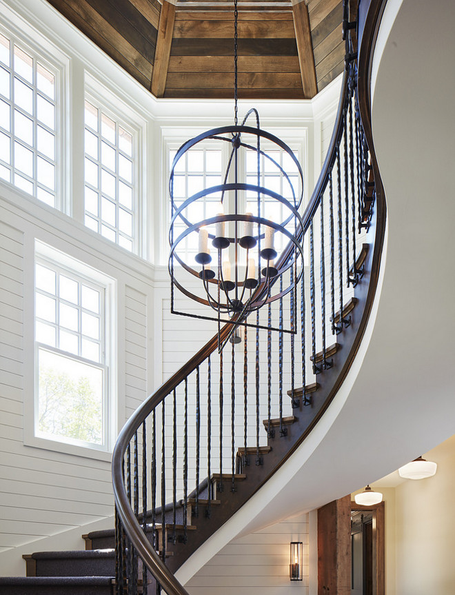 Farmhouse Staircase with white shiplap walls and stained wood shiplap ceiling. Farmhouse-inspired curved staircase with trimmed shiplap walls. white shiplap walls #Farmhouse #Staircase #whiteshiplap #shiplapwalls #shiplap #stainedwoodshiplap #shiplapceiling John Kraemer & Sons
