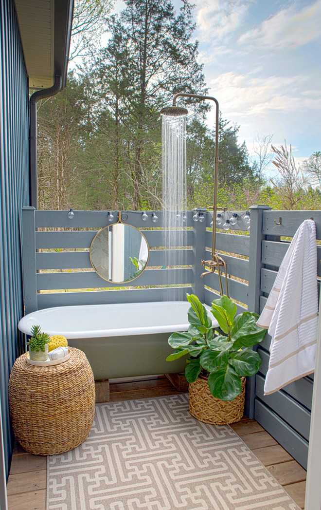 Outdoor Shower Fence. The Outdoor Shower Fence is pressure-treated 1x4's painted with exterior paint. The designer's husband built it and it's parallel style fence. The blue was color match to the color of our board and batten siding. #outdoorshowerfence #outdooorshowerfence #parallelstylefence Sharon Barrett Interiors