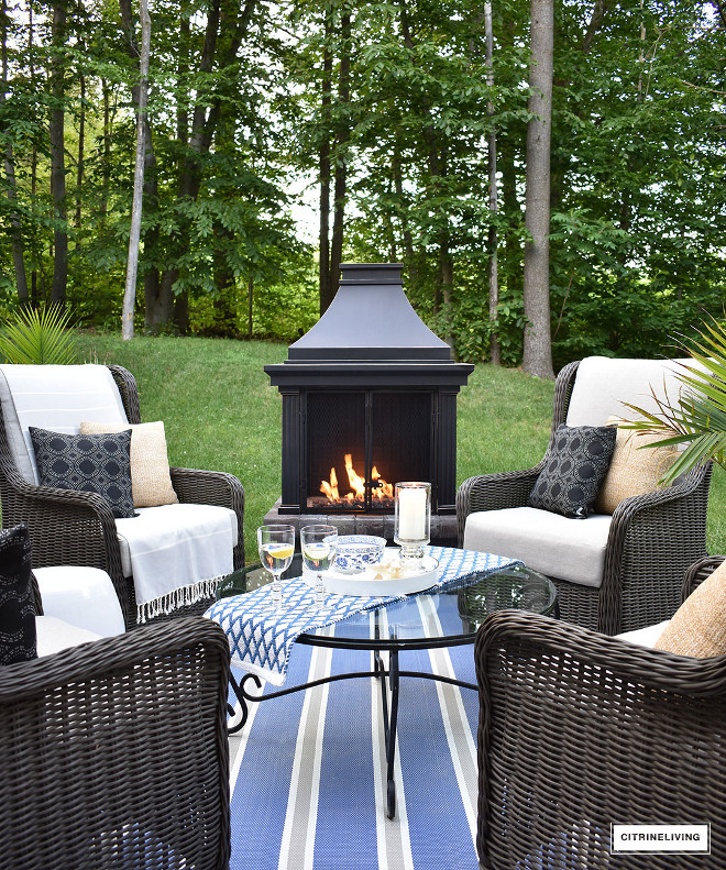 outdoor-fireplace-lounge-area-whicker-wingback-chair-blue-and-white-striped-rug Beautiful Homes of Instagram @citrineliving Home Bunch