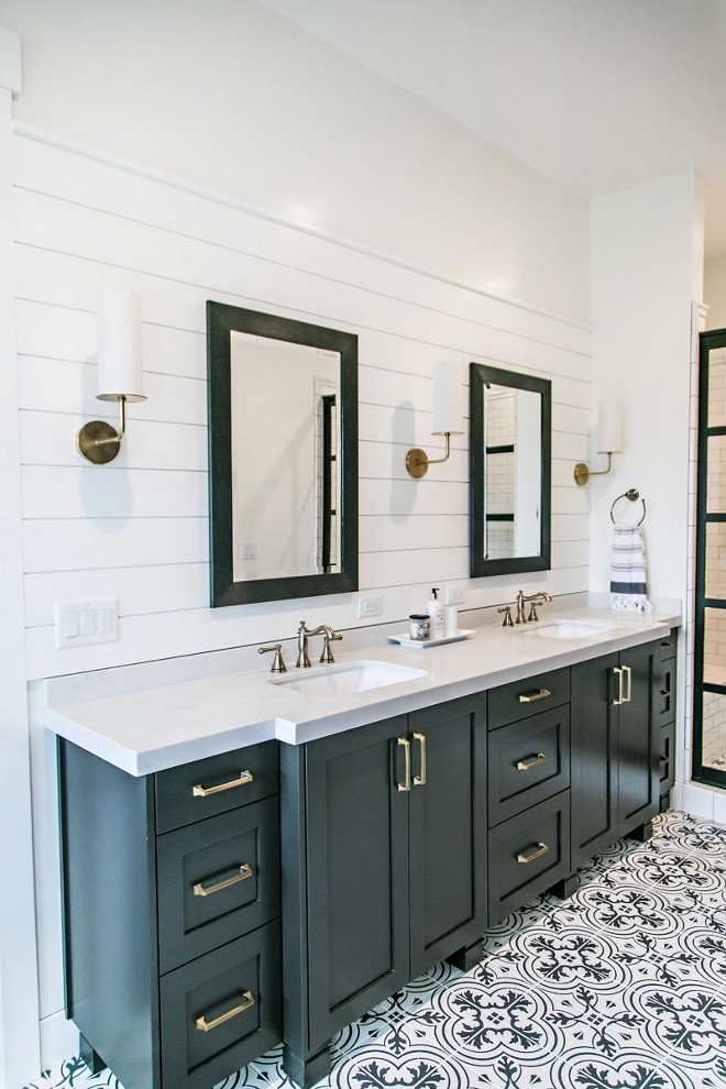 Farmhouse Bathroom. Farmhouse bathroom with black cabinet, shiplap behind vanity, black framed mirrors, black framed shower doors, black and white patterned tiles, brass hardware and lighting and white quartz countertop. #farmhouse #bathroom #farmhousebathroom #shiplap #patternedtiles #patternedtile #brasshardware #blackandwhite #bathrooms #tile #farmhouse #whitequartz #countertop Sita Montgomery Interiors