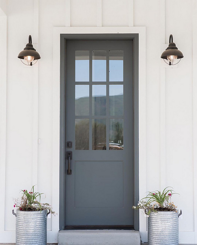 Farmhouse front door with zinc planters. Farmhouse with board and batten siding, grey front door with zinc planters. Farmhouse front door with zinc planters #Farmhouse #frontdoor #zincplanters Millhaven Homes