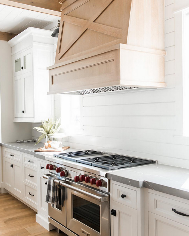 Farmhouse kitchen with white oak hood and shiplap backsplash. Millhaven Homes