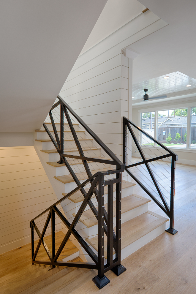 Farmhouse staircase. Metal farmhouse staircase. This farmhouse stair is made of black steel, crossed barn look guardrails and steel cable wire. Walls are shiplap. Farmhouse stair made of black steel, crossed barn look guardrails with steel cable wire and shiplap walls. #farmhousestair #staircase #farmhousestaircase #crossedstaircase #steelcablestaircase AK Construction