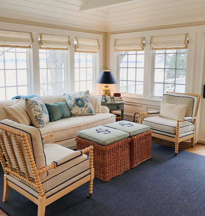 Sitting room. Coastal sitting room with spindle chairs, blue and white pillows, white linen Roman shades, rattan ottomans and navy blue rug. #sittingroom #coastal #coastalinteriors Beautiful Homes of Instagram @SweetShadyLane