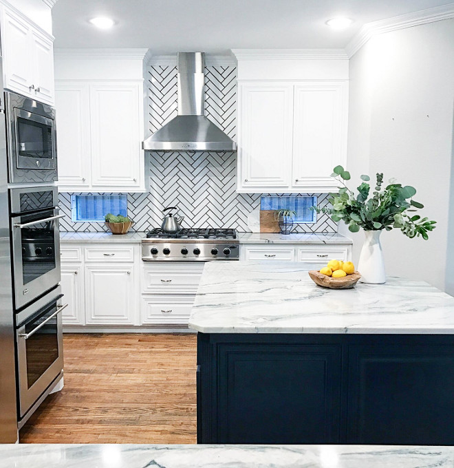 White kitchen with herringbone backsplash with black grout. Cabinet paint color is Benjamin Moore Chantilly Lace. Tile is Daltile Modern Dimensions Glazed Ceramic, 0190 in Arctic White. White kitchen with herringbone backsplash with black grout. White kitchen with herringbone backsplash with black grout. White kitchen with herringbone backsplash with black grout. #Whitekitchen #herringbonebacksplash #blackgrout Lark Interiors