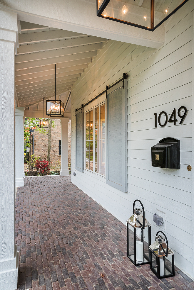 Brick Porch. Long porch with brick floor tile and grey shutters with barn door hardware Brick Porch. Long porch with brick floor tile and grey shutters with barn door hardware #Brick #Porch #brickporch #brickfloortile #greyshutters #barndoorhardware