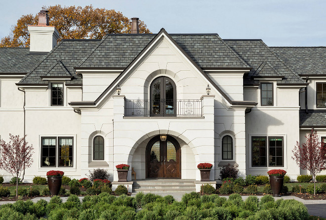 French style home with beige stucco siding and black windows