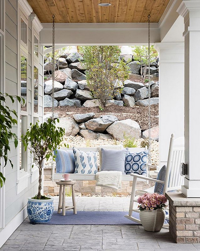 Front porch swing with blue and white pillows