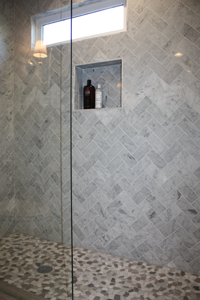 Herringbone marble tile with pebble floor tile shower