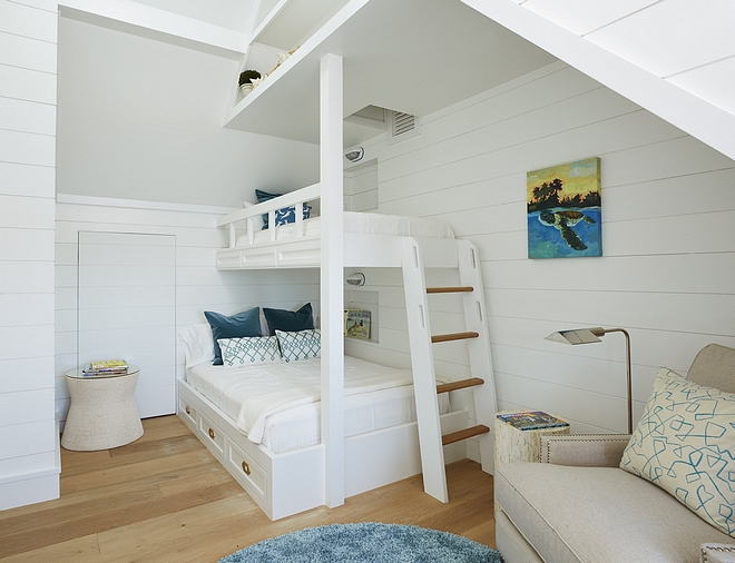 Bunk room features shiplap and custom storage above bunk beds