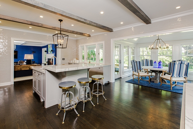 Kitchen opens to a breakfast room and family room Notice the floor-to-ceiling grey tile and ceiling beams