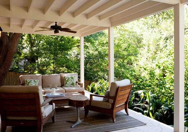 Farmhouse porch with Teak patio furniture and surrounded by plants