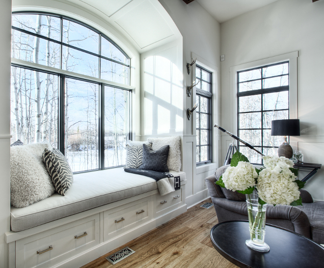 Arched Window-seat Great room with built-in day bed featuring a barrel arch and wainscoting throughout and black windows #windowseat #blackwindows #archedwindow