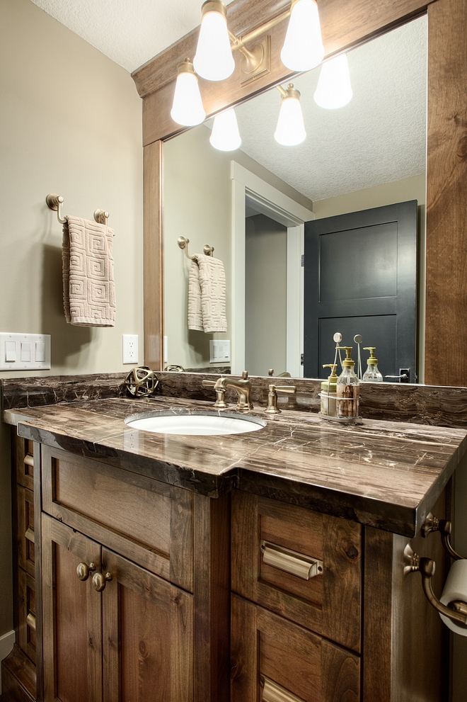 Basement bathroom features Alder cabinetry and a dark marble countertop #basementbathroom