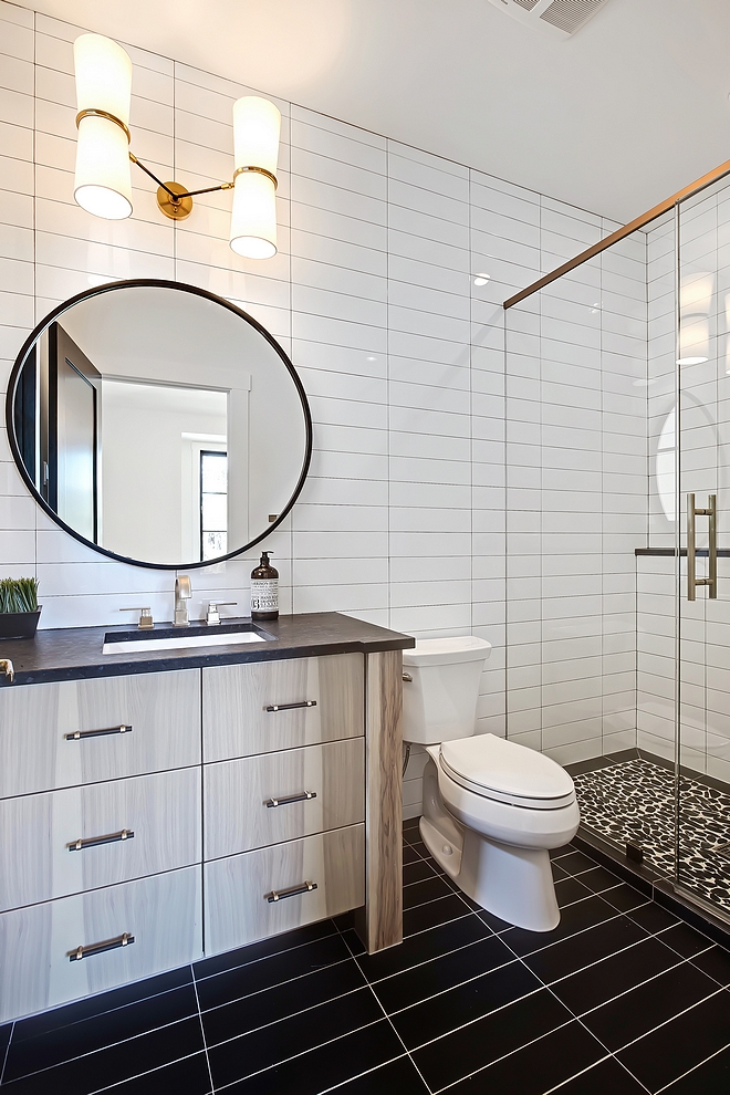 Bathroom with 4x16 white subway tile in a horizontal stack pattern on walls and 4x16 black subway tile in a stack pattern on floors #bathroom #4x16subwaytile #stacktilepattern #stacktile #stackpattern