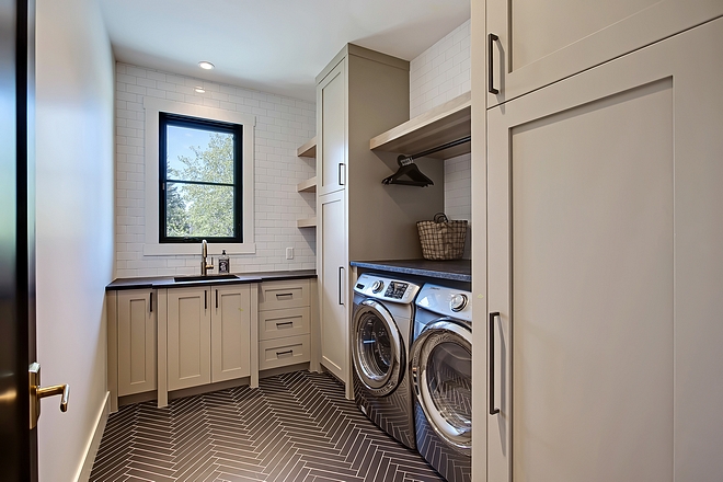 Laundry Room Layout Large laundry room with fixed hickory shelving and lacquered cabinets to the ceiling and hanging rod above the washer and dryer #LaundryRoom #LaundryRoomLayout