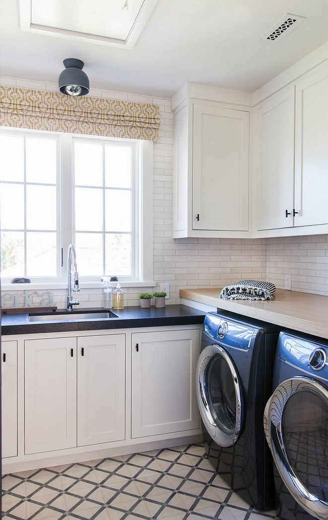 Laundry room with off white cabinets Cabinet Paint Color Farrow and Ball 2001 Strong White and two types of countertop Leathered Black Granite by sink and White Oak over washer and dryer #laundryroom