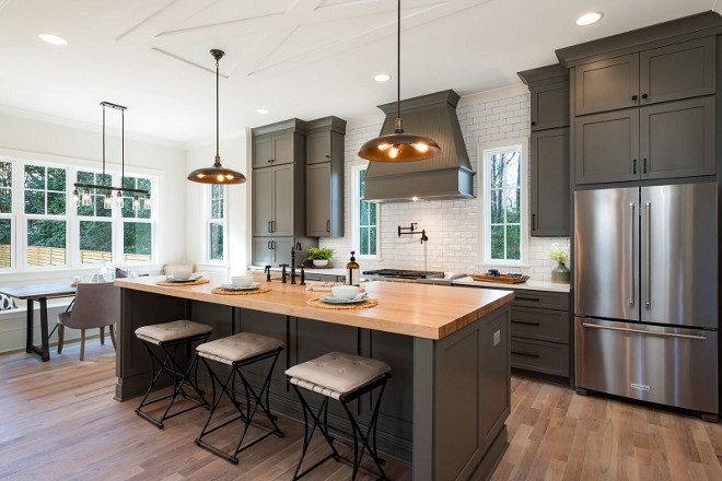 Grey Farmhouse Kitchen Staying true to the modern farmhouse style, we choose the green/grey custom colored cabinets The ceiling trim accents (above pendants) were crafted to look like a traditional barn door #GreyFarmhouseKitchen
