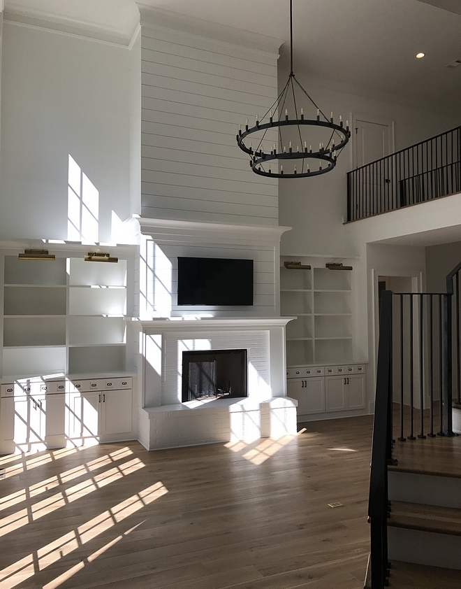 Living Room tall shiplap Built-ins add to the livability to the space while a tall fireplace balances the high ceiling Fireplace Tall fireplace with shiplap paneling Living room high ceiling fireplace #tallfireplace #highceiling #livingroom #fireplace