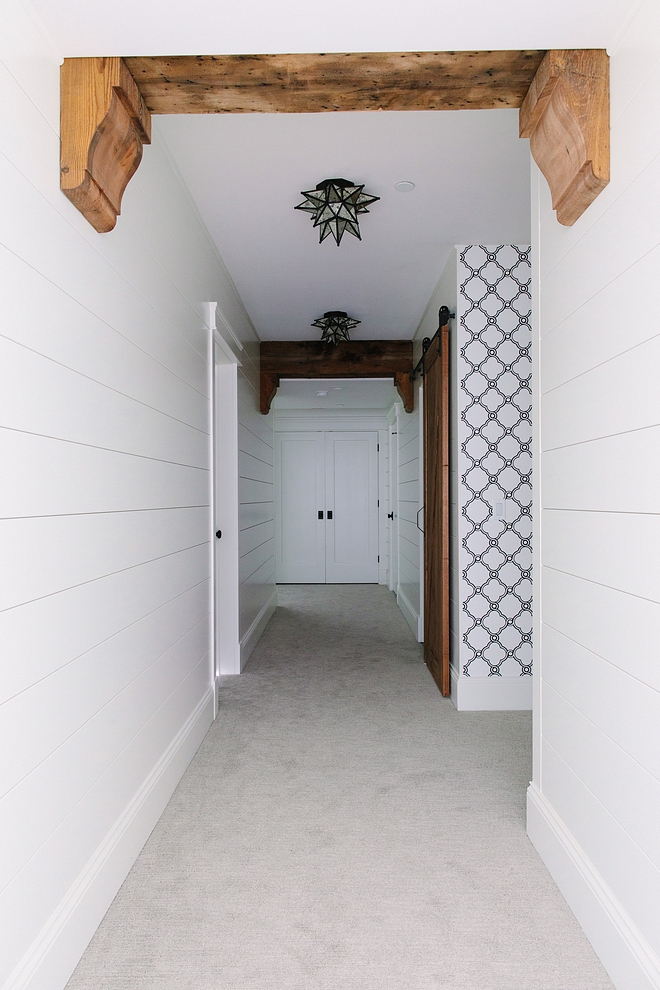 The basement features shiplap walls, painted in Benjamin Moore Simply White and rustic ceiling beams The exposed beams are actually barn wood that the designer covered duct work to disguise it They had the barn wood corbels made of real barn beams #beans #barnwood #reclaimedbeams #basement #shiplap