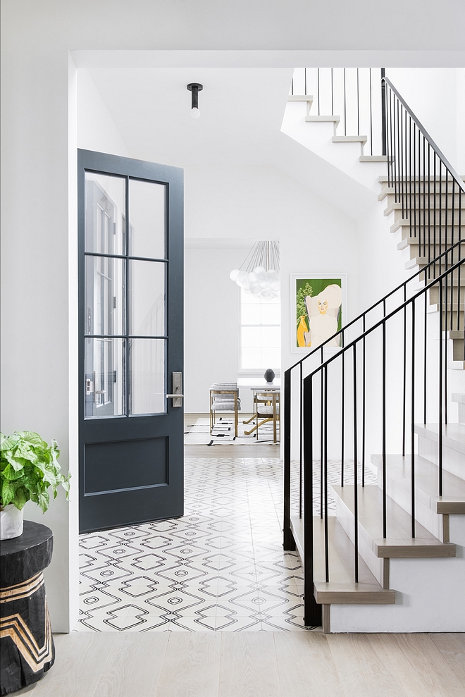 Foyer The tile landing meets the main stairwell which features simple architectural prominence, yet is still remarkably impressionable with the continuation of wood flooring treads, plaster walls, a custom metal railing #foyer #metalrailing #railing
