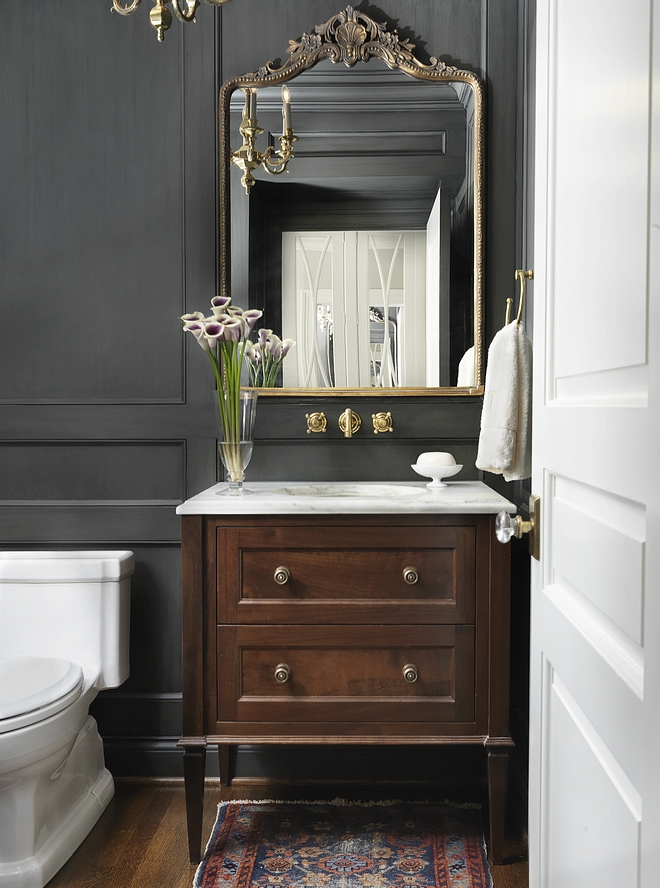 Powder room This chic and classic powder room features a custom furniture-looking vanity with white marble countertop and floor-to-ceiling paneling, painted in a custom charcoal stain color #powderroom