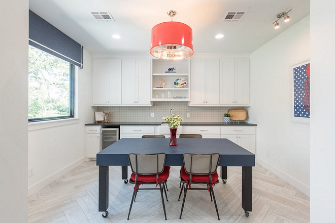 Craft Room Art Studio This craft room features a custom table, custom cabinetry with sink and herringbone flooring #Craftroom #Artstudio