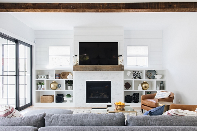 The family room features reclaimed ceiling beam and shiplap above built-ins and mantel #familyroom #reclaimedceilingbeam #shiplap #mantel