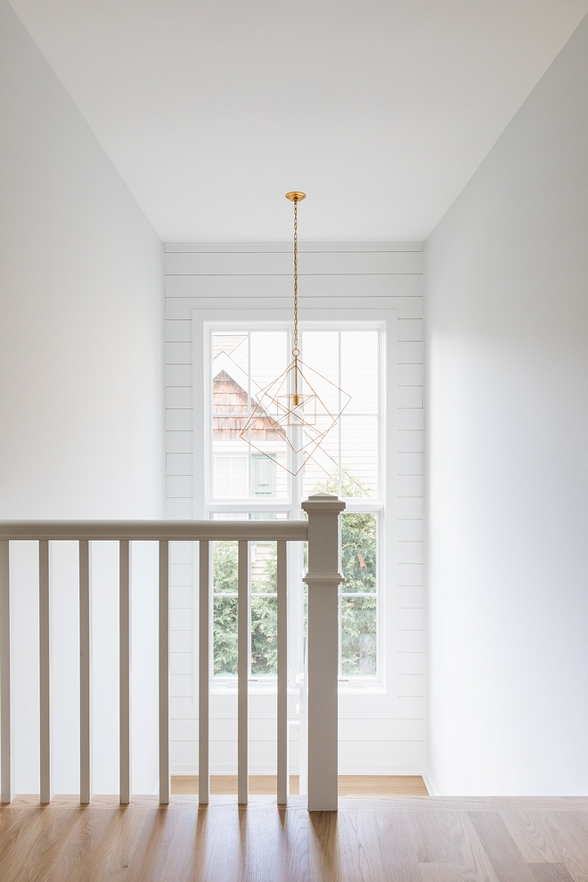 The staircase also features shiplap on an accent wall, framing a tall window Millwork is painted in Sherwin Williams Extra White #staircaseshiplap #staircase #shiplap #Sherwinwilliamsextrawhite #tallwindows