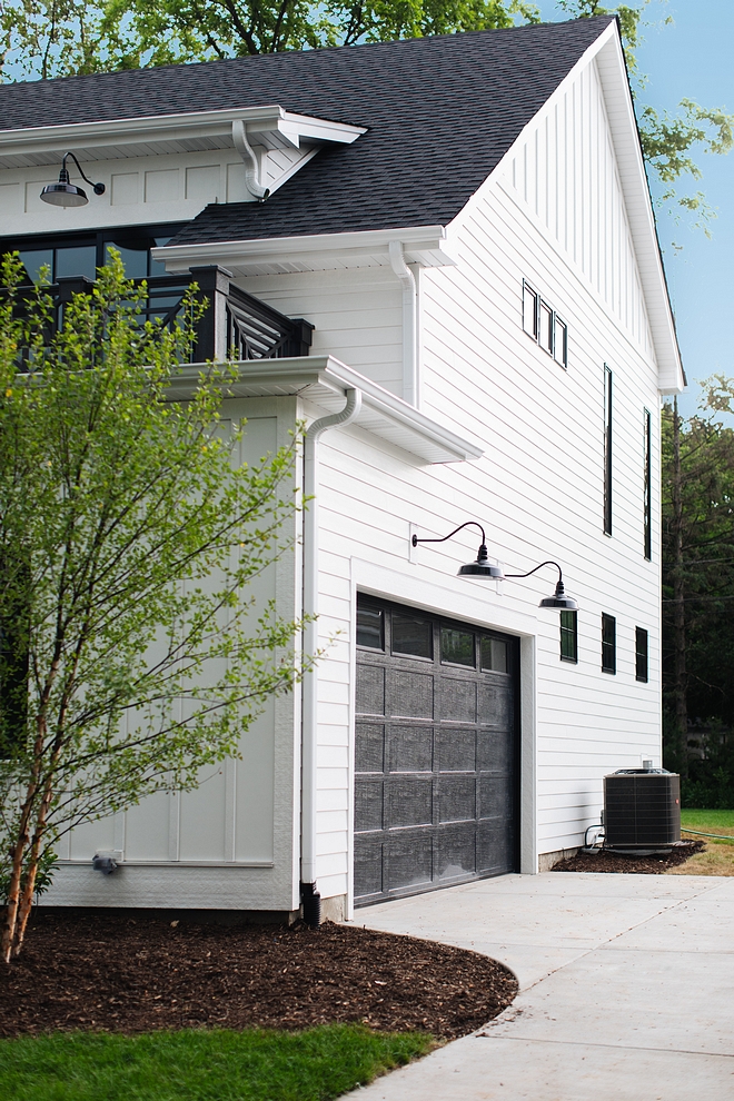 Farmhouse garage Black Garage doors for modern farmhouse The side entry garage - with balcony over it - features black garage door painted in Sherwin Williams SW 7069 Iron Ore #Farmhousestyle #blackgaragedoor #garage #farmhousegarage 
