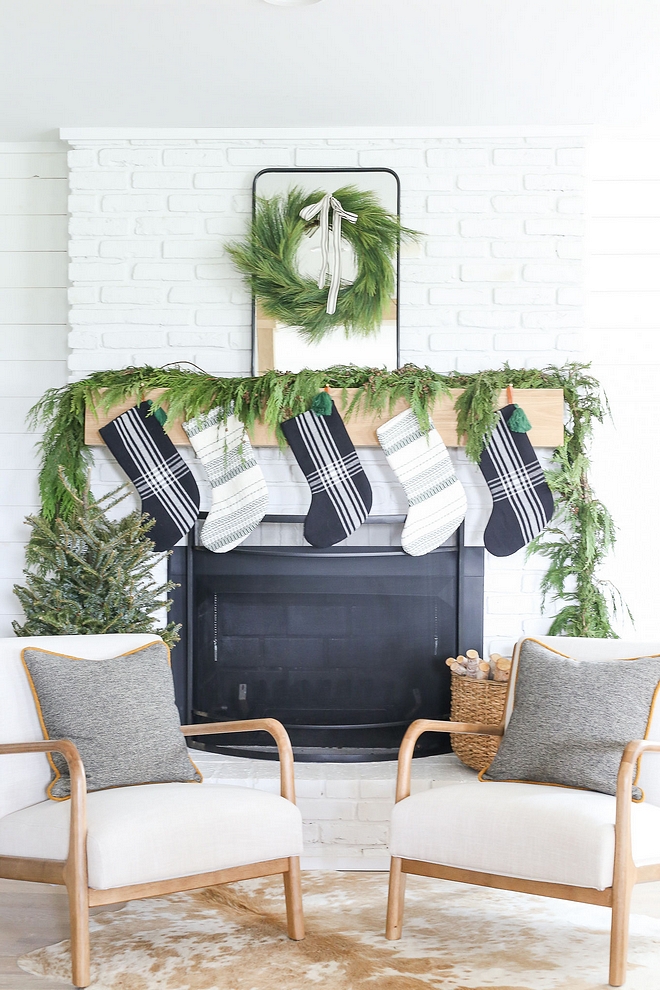 decorated her stunning fireplace with a natural Cedar garland, Cedar wreath and beautiful stockings The homeowner decorated her stunning fireplace with a natural Cedar garland, Cedar wreath and black and white stockings #minimalistchristmas #chirstmas #christmas