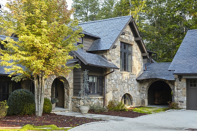 Rustic stone home exterior with Slate roof, arched breezeway Siding is undressed pine with mitered corners #rusticstonehome #stonehome #stonehomes #exterior #rusticexteriors