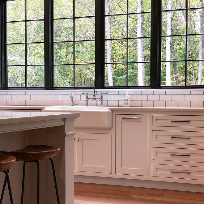 Benjamin Moore Chantilly Lace kitchen cabinet with Polished Chrome Hardware and black steel windows #BenjaminMooreChantillyLace #whitekitchen #ChromeHardware #blackwindows