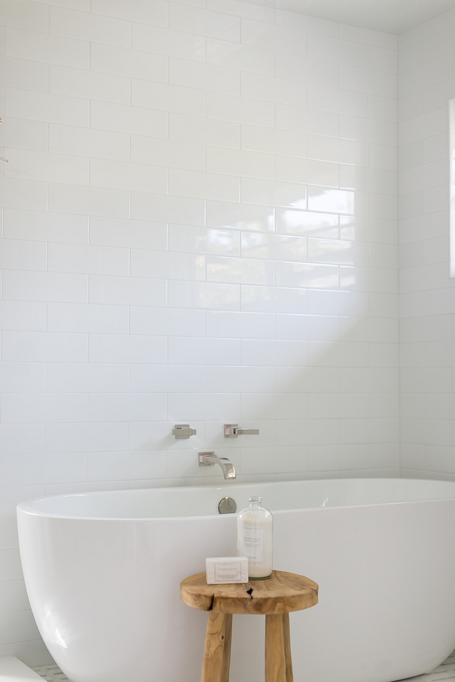 Simplicity is best when it comes to design bathrooms This spa-like bathroom features a sleek freestanding tub, a modern wall-mounted tub filler and large white subway tile on walls #bathroomdesign #bathroom #spabathroom