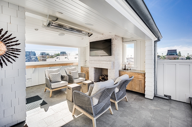 The rooftop features covered and non-covered areas, a TV, built-in bbq, under counter refrigerator, ice maker, sink, counterspace, sofa and lounging area, built-in fireplace #rooftop #decor #outdoors