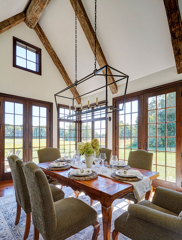 Dining Room Reclaimed wood beam Reclaimed hand hewn barn beams are used for the ridge beam in the vaulted dining room ceiling while floor-to-ceiling windows and French doors frame the country view #diningroom #reclaimedwoodbeam #beams #windows #ceiling #doors #diningroom