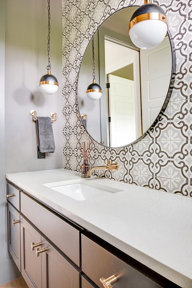 Powder room features a custom grey floating vanity, charcoal gray and light gray cement tile as an accent wall and globe mini-pendants #powderroom #bathroom #cementtile #floatingvanity