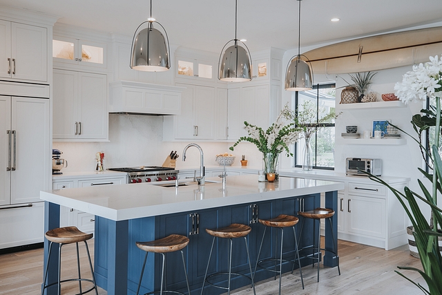 This coastal inspired home features a denim blue island as the focal point of the contrasting white kitchen #coastalkitchen #blueandwhitekitchen #kitchen #homedecor #coastalhomes