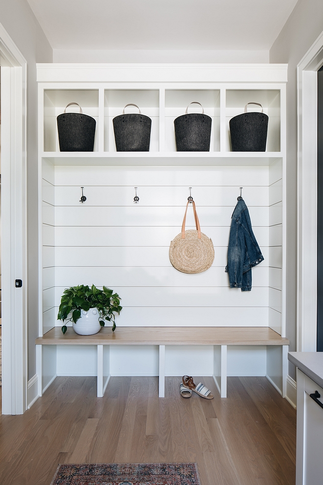 The mudroom features shiplap and custom cabinetry with White Oak seat