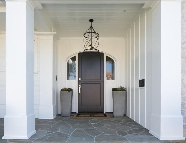 Front Door. Front entry with black front door, stone porch, white exterior and modern planters from Restoration Hardware. Front door lantern. #FrontEntry #FrontDoor #WhiteExterior #Planters #FrontDoorLighting #Lantern