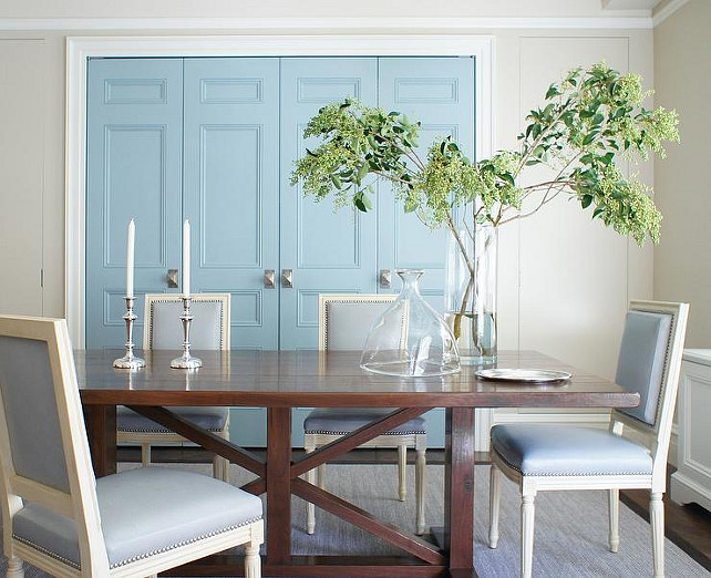 Blue Dining Room. Blue Dining Room Design Ideas. Blue dining room boasts a trestle dining table surrounded by blue French dining chairs with nailhead atop a gray rug and blue doors. #DiningRoom #BlueDiningRoom Christopher Burns