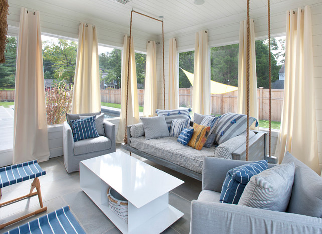 Screened in Porch with Curtains. Porch with Curtains & Swing. Screened-in porch featuring shiplap siding and ceiling, curtains, heated flooring and interchangeable glass and screens, and access to the pool area. #ScreenedinPorch #Curtain Blue Water Home Builders.
