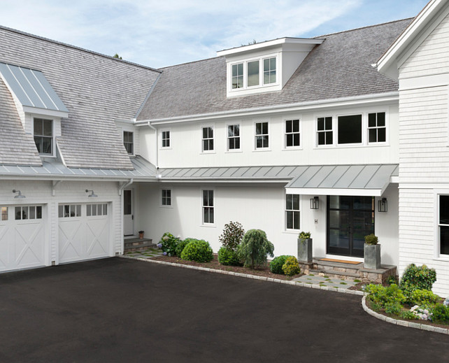 Farmhouse. Modern Farmhouse. White Modern Farmhouse. White Farmhouse Exterior. White Farmhouse with Black Windows, Black Steel Front Door and barn lights above garage door and metal roof details. #Farmhouse #FarmhouseExterior #WhiteFarmhouse #ModernFarmhouse Blue Water Home Builders.