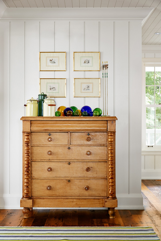 Unpainted Furniture Ideas. Some furniture is best left unpainted! This untouched pine spindle dresser adds handsome wood tones just off the dining room, while a palette of yellow, green, and indigo keeps the display of outdoor-themed finds—glass floats, camp pails, and antique arrows set in wax—feeling curated, not cluttered. #UnpaintedFurniture #FurnitureIdeas Designed by Sarah Richardson.